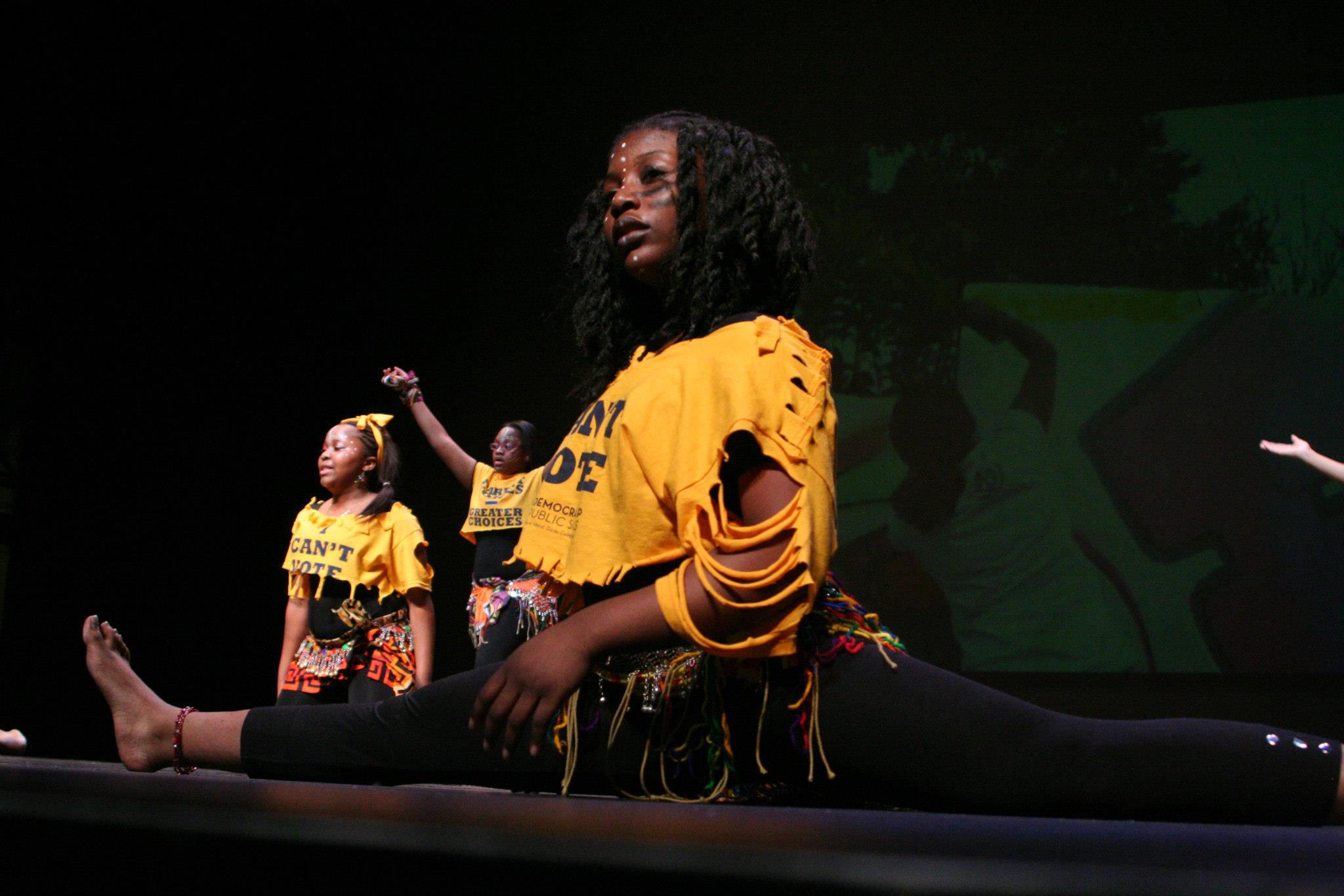 Siren dancer performing powerful splits on stage in 'I Can't Vote' campaign